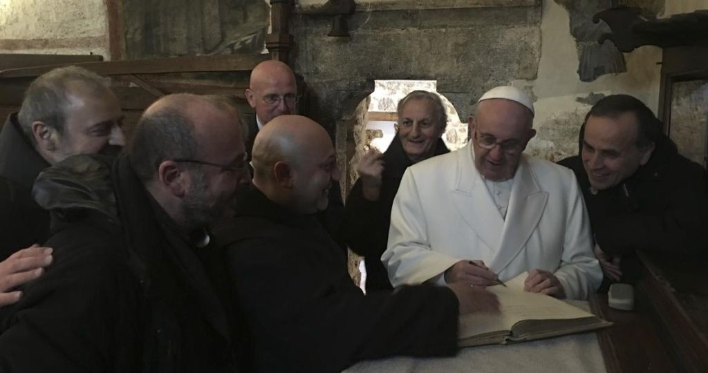Il-papa-firma-il-libro-dei-visitatori-attorniato-dai-francescani-che-reggono-il-santuario-e-dal-nuovo-vescovo-di-Rieti-mons.-Domenico-Pompili_imagefullwide